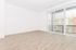 Modern apartment with abundant natural light through large windows with vertical blinds, offering a spacious and inviting atmosphere.