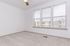 Bright and airy room with large windows and plush carpeting, offering a serene and modern living space.