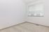 Bright and inviting empty room with large window, soft beige carpet, and fresh white walls.