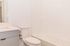 Bright, modern bathroom featuring sleek white fixtures and a cozy bathtub, perfect for relaxation.