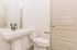 Modern bathroom with elegant pedestal sink and sleek fixtures, showcasing minimalist design and premium finishes.