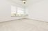 Bright and airy empty room with large windows, soft carpet, and ceiling fan, offering a blank canvas for personalization with natural light.