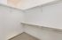 Spacious walk-in closet with sleek metal racks and plush carpeting, offering ample storage space.