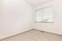 Bright and airy room with soft carpet and a large window featuring elegant blinds, perfect for a cozy living space.
