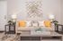 Modern living room with elegant beige sofa adorned with stylish yellow and white pillows, contemporary wall art, and chic side tables with decorative lamps.