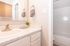 Chic bathroom with elegant marbled countertop, sleek faucet, and soft-toned decor, offering a serene and stylish ambiance.