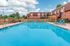 Inviting outdoor swimming pool area with comfortable loungers, perfect for relaxation under a beautiful blue sky.