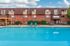 Inviting apartment complex with refreshing swimming pool, outdoor seating, and charming brick exterior.