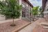 Charming apartment complex exterior with lush greenery and inviting entrance, featuring sleek stairways leading to the leasing office.
