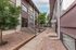 Inviting apartment complex entrance with landscaped pathways and lush trees leading to the leasing office.