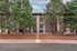 Charming residential building surrounded by lush green pine trees, offering a serene and welcoming atmosphere.