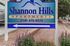 Welcome to Shannon Hills Apartments, vibrant sign surrounded by lush greenery and convenient access directions.