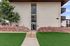 Charming residential entrance with vibrant landscaping, inviting pathway, and modern architecture.