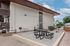 Modern apartment building with an inviting outdoor picnic area and sleek architecture under a bright blue sky.