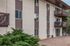 Elegant apartment building exterior with private balconies and lush greenery, offering a serene and inviting living environment.
