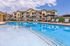 Inviting apartment complex with a luxurious pool area featuring comfortable sun loungers and modern amenities, perfect for relaxation and enjoyment.