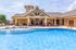 Inviting outdoor pool area with stylish seating and vibrant flower decorations, perfect for relaxing and enjoying sunny days.