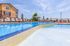Inviting outdoor swimming pool with luxurious lounge chairs and a charming pergola, perfect for relaxation and leisure.