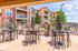 Vibrant apartment community featuring elegant outdoor BBQ area with stylish seating and modern grills, surrounded by lush greenery and colorful flowers.