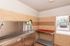 Bright and functional laundry room featuring modern stainless steel washing facilities, tiled walls, and convenient shelving.