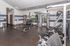 Modern gym with state-of-the-art equipment including weight benches, dumbbells, and fitness machines, in a spacious and well-lit area.