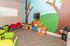 Vibrant kids' playroom featuring colorful bean bags, educational books, and playful murals for a lively and inviting atmosphere.