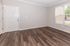 Inviting empty room showcasing elegant hardwood floors, neutral walls, and large windows for abundant natural light.
