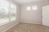 Bright and airy bedroom with plush carpeting, large windows showcasing a charming outdoor view, and a neutral palette perfect for customization.