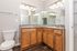 Elegant bathroom featuring dual sinks, expansive mirrors, and stylish wooden cabinetry with modern fixtures.