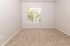 Bright and cozy room with plush carpet and large window offering serene garden views.