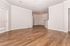 Spacious living area with elegant wood flooring, natural light, and modern open layout.
