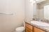 Bright and stylish bathroom featuring a modern sink with a marble countertop, wooden cabinetry, and elegant lighting.