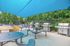 Inviting outdoor BBQ area with modern grills, shaded seating, and vibrant greenery, perfect for social gatherings and relaxation.