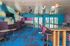 Vibrant lounge space with modern decor, featuring colorful walls, plush seating, and a stylish bar area with unique lighting fixtures.