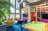 Vibrant communal lounge with modern decor, featuring a pool table, cozy seating, and large windows for natural light.