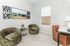 Chic home office with modern decor, featuring plush olive chairs, a sleek white desk, and vibrant wall art for a cozy workspace.