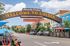 Charming street view of Golden, showcasing a welcoming archway, colorful storefronts, and vibrant outdoor seating under clear blue skies.