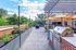 Chic rooftop terrace with lush planters, modern grill station, and cozy seating under vibrant yellow umbrellas.