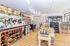 Charming gourmet shop interior with wooden floors, stylish counters, and a diverse selection of wines and artisanal products.