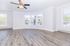 Bright and airy living space with large bay windows, elegant ceiling fan, and sleek wood flooring, perfect for modern urban living.