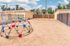 Inviting outdoor playground with colorful climbing dome and swing set, perfect for family fun in a secure sandy area.