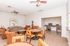 Chic communal living room with stylish seating, round table, vibrant art, and a cozy workspace nook.