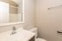 Modern bathroom with sleek fixtures, sparkling countertop, and elegant mirror, offering a fresh and inviting space.