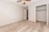 Bright and inviting bedroom with plush carpeting, ceiling fan, and a spacious closet, perfect for comfortable living.