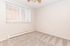 Bright and inviting room with plush carpet flooring and large window blinds, ideal for a cozy bedroom retreat.