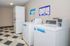 Modern laundry room featuring efficient stacked washers and dryers with no coin needed payment options, highlighted against a stylish, geometric tiled floor.