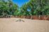 Expansive dog park with agility equipment and lush green trees, perfect for pet-friendly living.