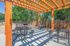 Charming outdoor space with a wooden pergola, stylish metal picnic tables, and a built-in barbecue grill, perfect for entertaining and relaxation.