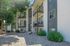 Inviting apartment building with modern balconies, lush greenery, and charming pebble landscaping.