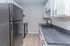 Sleek modern kitchen with elegant black appliances, pristine white cabinets, and stylish countertops, offering a bright and functional cooking space.